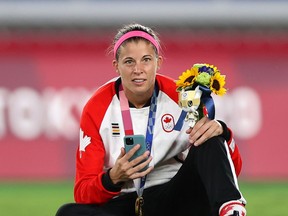 YOKOHAMA, JAPAN - AUGUST 06: Gold medalist Stephanie Labbe  of Team Canada poses with her gold medal whilst on the phone during the Women's Football Competition Medal Ceremony on day fourteen of the Tokyo 2020 Olympic Games at International Stadium Yokohama on August 06, 2021 in Yokohama, Kanagawa, Japan.