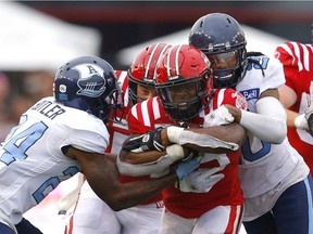 The Calgary Stampeders Ka'Deem Carey is tackled by Toronto Argonauts Crezdon Butler in second half CFL action at McMahon stadium in Calgary Saturday, August 7, 2021. Darren Makowichuk/Postmedia