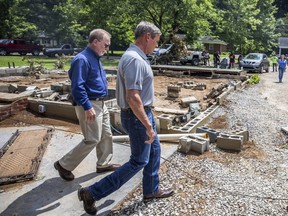 Tennessee Gov. Bill Lee (right) walks past a home swept off its foundation due to catastrophic floods in Waverly, Tenn., Sunday, Aug. 22, 2021.