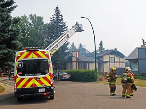 Calgary firefighters battle a fire in two homes on Woodfield Close S.W. on Sunday, August 1, 2021.