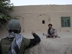 An Afghan villager speaks through an interpreter to Sergeant Jimmy Butler of India Company, 2nd Batallion Royal Canadian Regiment (2 RCR) in a village near the Canadian Forward Operating Base (FOB) at Ma'sum Ghar, Afghanistan, on June 18, 2007.