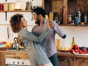 Young african-american couple dancing in kitchen, copy space