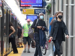 City transit users are seen wearing masks on a CTrain platform in downtown Calgary on  Tuesday, Aug. 3, 2021. Masks are still required on public transport in the city.