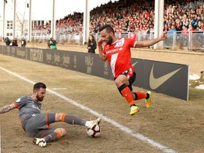 Cavalry FC forward Sergio Camargo (right) is tackled by Forge FC defender David Edgar During Leg 2 of the Canadian Premier League Championship at ATCO Field at Spruce Meadows in Calgary on Nov. 2, 2019. Forge won 1-0 and were crowned league champions.