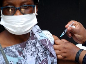 A healthcare worker administers the Johnson and Johnson coronavirus disease (COVID-19) vaccination to a woman in Houghton, Johannesburg, South Africa, August 20, 2021.