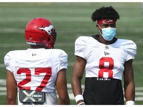 Stamps defensive backs Jonathan Moxey (L) and DaShaun Amos pass each other on the sidelines during practice at McMahon Stadium in Calgary on Saturday, July 24, 2021. Jim Wells/Postmedia