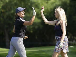 Tamara MacDonald, left, and Sue Riddell Rose high five during Blakes Women’s Day at the Shaw Charity Classic at Canyon Meadows Golf & Country Club in Calgary on Monday, Aug. 9, 2021.