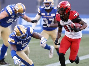 Calgary Stampeders returner Malik Henry (right) carries a missed field goal out of the end zone and past a diving Winnipeg Blue Bombers DE Willie Jefferson during CFL action at IG Field in Winnipeg on Sun., Aug. 29, 2021. KEVIN KING/Winnipeg Sun/Postmedia Network