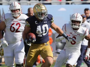 CHICAGO, ILLINOIS - SEPTEMBER 25: Drew White #40 of the Notre Dame Fighting Irish returns an interception for a touchdown chased by Cormac Sampson #62 and Kendric Pryor #3 of the Wisconsin Badgers at Soldier Field on September 25, 2021 in Chicago, Illinois. Notre Dame defeated Wisconsin 41-13.