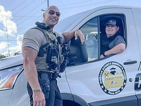 Patrol Lieutenant Eric Fields with the Morgan County Sheriff’s Office stands outside police vehicle. Fields bears a striking resemblance to Dwayne ’The Rock’ Johnson.