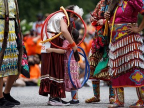 Hoop dancer Emilee Ann, left, hugs her friend Ayiana Myran as they wait to perform alongside other dancers at Toronto City Hall during the Every Child Matters walk in honour of children who lost their lives in Canada's Residential School system, in Toronto, Canada, on July 1, 2021.