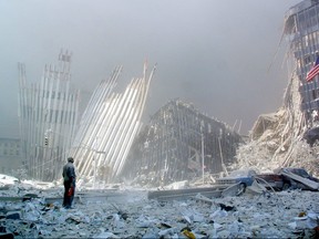 In this file photo taken on Sept. 11, 2001, a man stands in the rubble, and calls out asking if anyone needs help, after the collapse of the first of the twin towers of the World Trade Center Tower in lower Manhattan, New York.