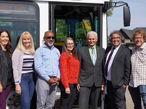Calgary Mayor Naheed Nenshi (second from right) and Chestermere Mayor Marshall Chalmers (third from right), pose for a photo with Calgary and Chestermere council members after announcing a new transit link between the two municipalities on Monday, Aug. 30.