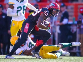 Calgary Stampeders receiver Kamar Jorden runs after a catch against Darius Williams and Brian Walker of the Edmonton Elks at McMahon Stadium in Calgary on Monday, Sept. 6, 2021.