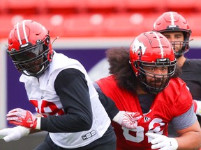 Stampeders o-lineman Nila Kasitati battles Chris Odom during practice in Calgary on Thursday.