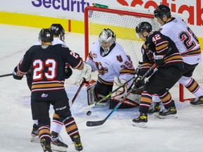 Goalie Brayden Peters of Team White makes a save on Oliver Tulk of Team Black as he battles Tyson Galloway in front of Zac Funk of Team White, and Adam Kydd of Team Black, during the Calgary Hitmen’s intrasquad game at the Saddledome in Calgary on Tuesday, Sept. 7, 2021.