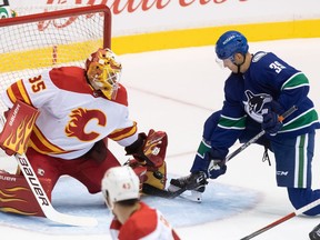 Calgary Flames goalie Adam Werner (35) stops Vancouver Canucks' Alex Chiasson (39) during the first period of a pre-season NHL hockey game in Abbotsford, B.C., Monday, Sept. 27, 2021.