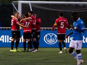 Cavalry FC’s Anthony Novak celebrates his goal against FC Edmonton goalkeeper Connor James with teammates during Canadian Premier League action at Clarke Stadium in Edmonton on Wednesday, Sept. 1, 2021.