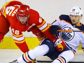 Calgary Flames prospect Colton Poolman battles against Ostap Safin of the Edmonton Oilers during an exhibition game in Calgary on Monday, September 20, 2021. Al Charest / Postmedia