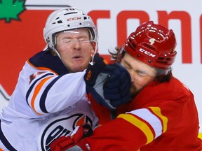 Edmonton Oilers Tyler Benson collides with Rasmus Andersson of the Calgary Flames during pre-season NHL hockey in Calgary on Sunday, September 26, 2021. AL CHAREST / POSTMEDIA