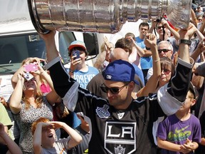 Then-Los Angeles Kings forward Brad Richardson hoists the Stanley Cup before hundreds of fans as he arrives with the coveted NHL trophy at Market Square in downtown Belleville, Ont., in this photo from Aug. 25, 2012.