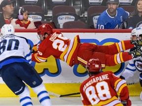 Calgary Flames forward Dillon Dube gets airborne as he fights for the puck against the Winnipeg Jets during Friday's preseason finale at the Scotiabank Saddledome.