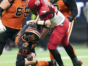 VANCOUVER, BRITISH COLUMBIA - OCTOBER 16: Jameer Thurman #56 of the Calgary Stampeders sacks quarterback Michael Reilly #13 of the BC Lions during the second half of CFL football action at BC Place on October 16, 2021 in Vancouver, British Columbia, Canada.