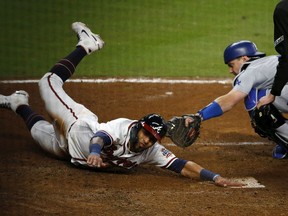 The Atlanta Braves’ Eddie Rosario slides safely past the Los Angeles Dodgers’ Will Smith to score in the eighth inning of Game 2 of the National League Championship Series at Truist Park in Atlanta on Sunday, Oct. 17, 2021 in Atlanta.