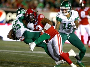 The Calgary Stampeders’ Darnell Sankey hits the Saskatchewan Roughriders’ Kyran Moore at McMahon Stadium in Calgary on Saturday, Oct. 2, 2021.