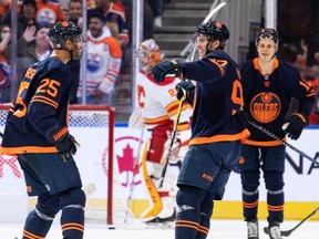 The Edmonton Oilers’ Connor McDavid celebrates a goal on Calgary Flames goaltender Jacob Markstrom with teammates at Rogers Place in Edmonton on Saturday, Oct. 16, 2021.