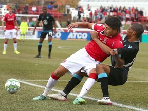 Cavalry FC’s Jose Hernandez is brought down outside the box by HFX Wanderers FC’s Alejandro Portal at ATCO Field at Spruce Meadows on Sunday, Oct. 17, 2021.
