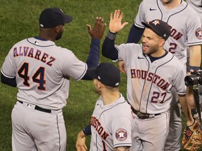 Houston Astros designated hitter Yordan Alvarez (left) and second baseman Jose Altuve high-five after defeating the Boston Red Sox.