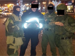 Photo posted to 4chan from user 'Moleman' shows three men posing for a photo with an Edmonton Police Service officer on Whyte Avenue on Halloween 2016.