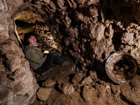 Historian Hanna Tychka explores a cave at the city sewage system where dozens of Jews were hiding from the Nazis during the Second World War in Lviv, Ukraine, Sept. 25, 2021.