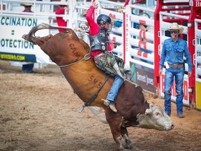 Dakota Buttar hangs on tight for an 90 on Timber Jam during the bull-riding event at the Calgary Stampede rodeo on Friday, July 9, 2021.