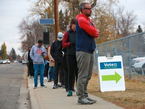 Calgarians wait in line to vote outside a Ward 9 polling station at Stanley Jones Elementary School on municipal election day, Monday, October 18, 2021.