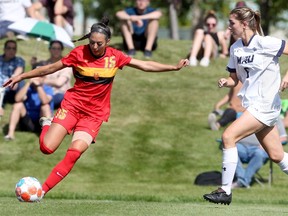 The Calgary Dinos’ Montana Leonard looks for a pass while covered by the Mount Royal Cougars during Mount Royals’ home-opener on Saturday, Sept. 4, 2021. The Dinos won 3-0