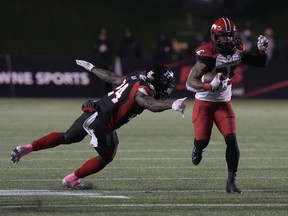 Calgary Stampeders running back Ka’Deem Carey evades a tackle by Ottawa Redblacks linebacker Micah Awe as he runs with the ball at TD Place Stadium in Ottawa on Friday, Oct. 29, 2021.