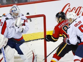 The Calgary Flames’ Andrew Mangiapane battles Washington Capitals goaltender Braden Holtby at the Scotiabank Saddledome in Calgary on Oct. 22, 2019.