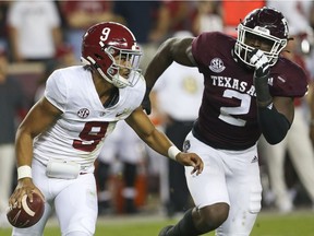 Alabama Crimson Tide quarterback Bryce Young is chased by Texas A&M Aggies defensive lineman Micheal Clemons at Kyle Field in College Station, Texas, on Saturday, Oct. 9, 2021.