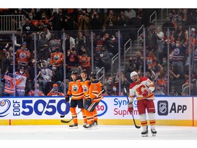 Edmonton Oilers' Jesse Puljujarvi (13) celebrates a goal with teammates on Calgary Flames' goaltender Jacob Markstrom (25) during second period preseason NHL action at Rogers Place in Edmonton, on Monday, Oct. 4, 2021. Photo by Ian Kucerak