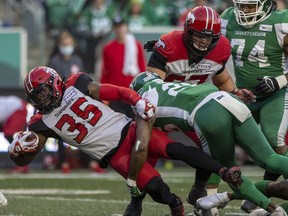 Calgary Stampeders running back Ka’Deem Carey  is tackled by Saskatchewan Roughriders defensive back Godfrey Onyeka at Mosaic Stadium in Regina on Saturday, Oct. 9, 2021.