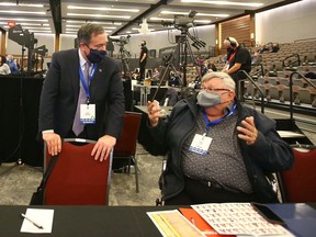 Alberta Premier Jason Kenney, left, chats with party members as he arrives into the main room at the United Conservative Party AGM on Tsuut'ina Nation near Calgary on Friday, November 19, 2021.