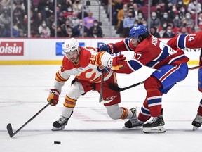 Flames winger Dillon Dube carries the puck with the Canadiens' Alexander Romanov in hot pursuit during the first period at the Bell Centre on Thursday night in Montreal.