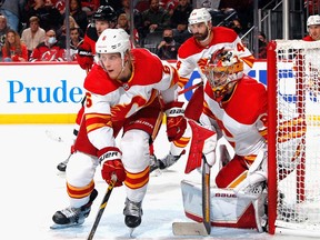 The Calgary Flames’ Juuso Valimaki and Dan Vladar defend the net against the New Jersey Devils at the Prudential Center in Newark, N.J., on Oct. 26, 2021.