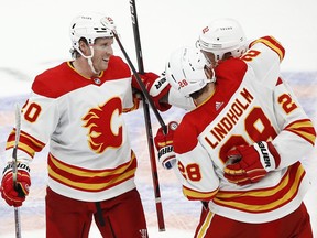 Blake Coleman (left) celebrates with Calgary Flames teammates during the club’s 3-2 win over the New York Islanders at UBS Arena in Elmont, N.Y., on Saturday, Nov. 20, 2021.