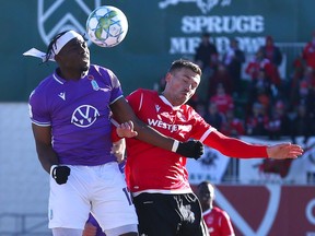 Cavalry FC’s Ben Fisk (right) and Pacific FC's Kunle Dada-Luke go airborne for a ball during the match at ATCO Field at Spruce Meadows on Sunday, Nov. 7, 2021.