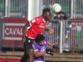 Cavalry FC’s Karifa Yao goes high over a Pacific FC defender during CPL semifinal action at ATCO Field at Spruce Meadows on Saturday, Nov. 20, 2021.