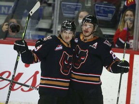 The Calgary Hitmen’s Sean Tschigerl (left) and Riley Fiddler-Schulz celebrate a goal by Tschigerl agains the Regina Pats at the Saddledome in Calgary on Sunday, Nov. 28, 2021.