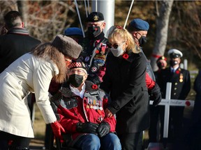 Veteran George Morasch (Calgary Highlanders) (seated) is accompanied during Remembrance Day ceremonies at the Field of Crosses on Memorial Drive in northwest Calgary on Thursday, November 11, 2021. Morasch landed in Normandy in 1944 and captured Hill 67 south of Caen.